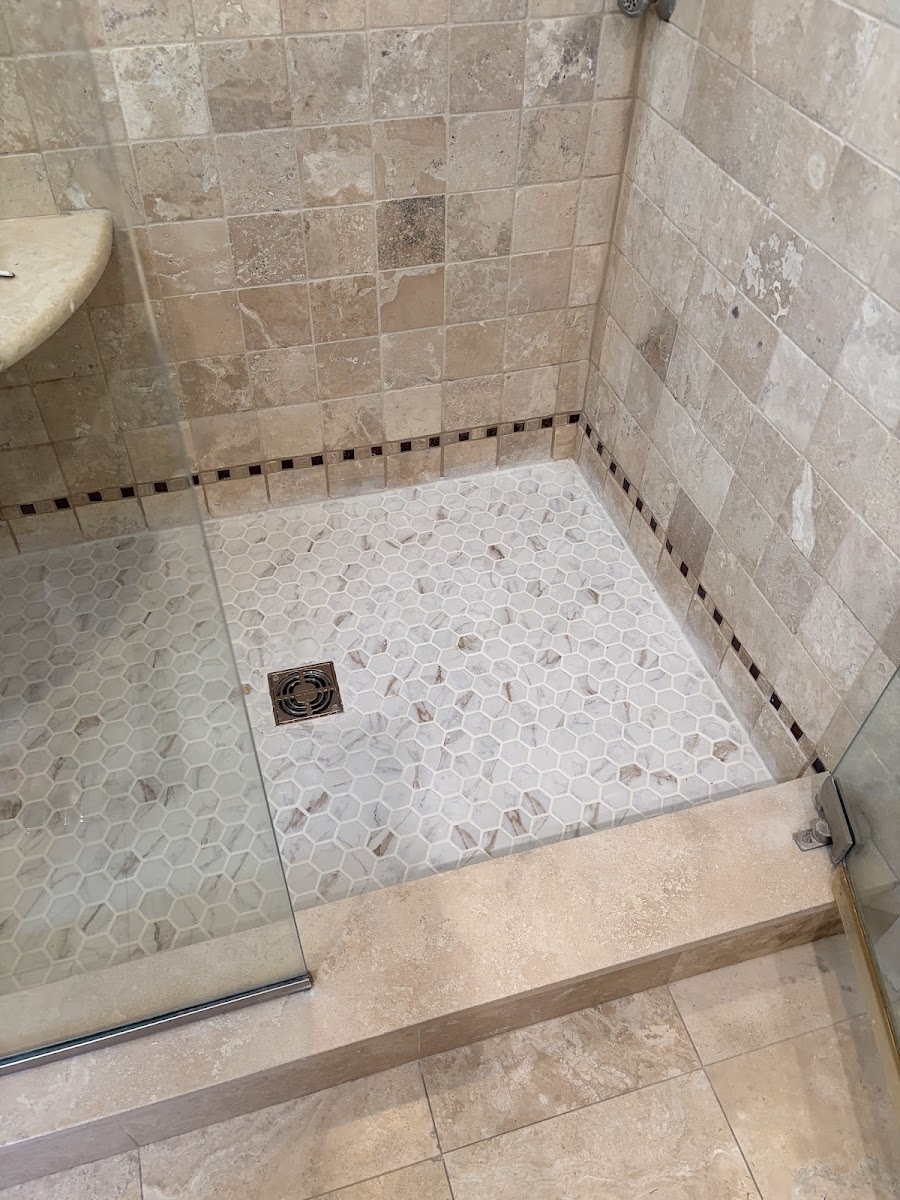 Walk-in shower with tiled walls and a mosaic tile floor